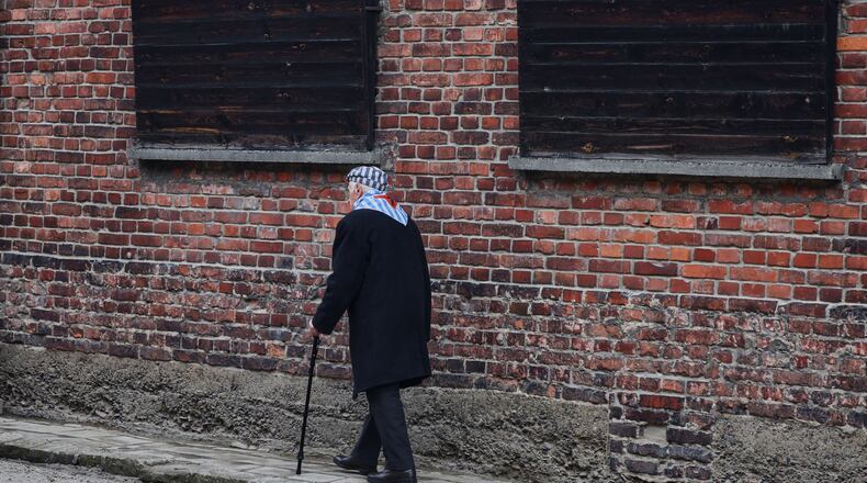Holocaust survivor Stanislaw Zalewski walks along a wall in the Auschwitz Nazi death camp museum during a ceremony marking the 81th anniversary of the camp's liberation in Oswiecim, Poland, Tuesday, Jan. 27, 2026. (AP Photo/Beata Zawrzel)