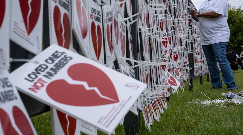 200827-Atlanta-Catolyn Merriweather, whose mother JoeAnn Snead died from Covid-19 in April, helps hang 5,000 broken hearts on the fence outside of the National Museum for Civil and Human Rights on Thursday evening August 27, 2020, as part of the “Loved Ones, Not Numbers” campaign to humanize the toll of the current pandemic. Ben Gray for the Atlanta Journal-Constitution
