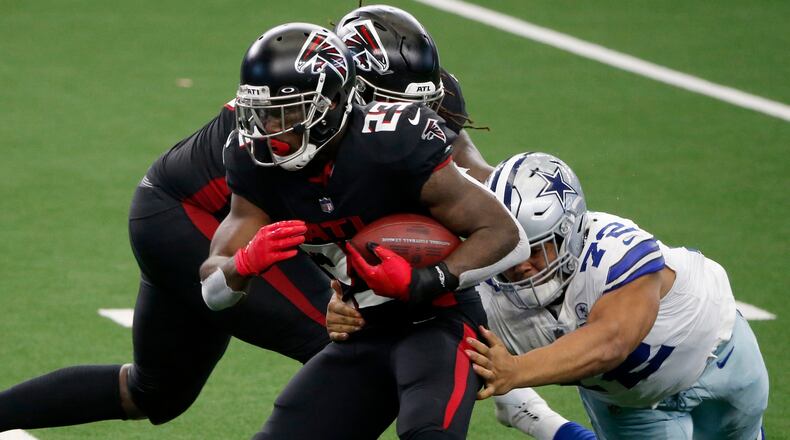 Falcons running back Brian Hill (23) runs the ball as Dallas Cowboys defensive tackle Trysten Hill (72) attempts to make a stop Sunday, Sept. 20, 2020, in Arlington, Texas. (Michael Ainsworth/AP)