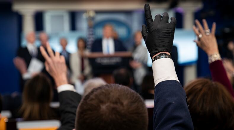 Reporters raise their hands to ask President Donald Trump questions during a press briefing with the coronavirus task force, at the White House, Monday, March 16, 2020, in Washington. (AP Photo/Evan Vucci)
