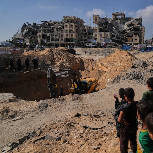 Palestinians watch as Egyptian machinery and workers search for the bodies of hostages in Hamad City, Khan Younis, in the southern Gaza Strip, Tuesday, Oct. 28, 2025. (AP Photo/Abdel Kareem Hana)