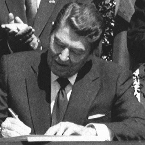 FILE - President Ronald Reagan signs legislation implementing the U.S.-Canada free trade agreement during a ceremony at the White House, Sept. 28, 1988. (AP Photo/Scott Stewart, File)
