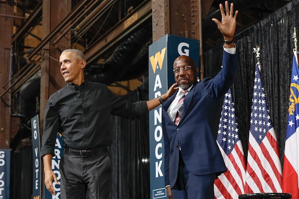 Former President Barack Obama and U.S. Sen. Raphael Warnock wave to supporters during a campaign rally at Pullman Yards in Atlanta on Dec. 1, 2022. (Natrice Miller/AJC)  