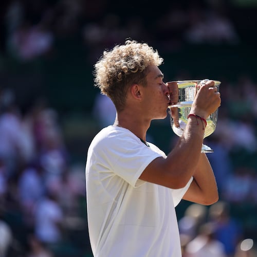 Jordan Lee of the United States kisses the trophy after winning against Cruz Hewitt of Australia in the boy's singles final at the Wimbledon Tennis Championships in London, Sunday, July 12, 2026. (AP Photo/Brian Inganga)