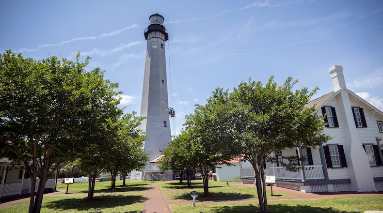 A crew works off scaffolding on the 145-foot Tybee Island lighthouse on May 23, 2024. The Historical Society is spending $1.8 million to replace the roof, the glass around the navigation light and the masonry on the 18th century landmark on Georgia's coast. (AJC Photo/Stephen B. Morton)