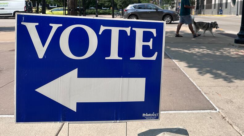 A person walks past a sign for a polling place on the first day of in-person absentee voting for Wisconsin's chaotic Democratic primary for governor Tuesday, July 28, 2026, in Madison, Wis. (AP Photo/Scott Bauer)