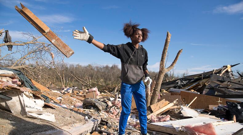 Asiah Bledsoe, sister of Brianna Bledsoe, clears through debris as she looks for a photo of a family member at her grandfather's tornado-wrecked home in Talbotton on Monday, March  4, 2019.  (ALYSSA POINTER/ALYSSA.POINTER@AJC.COM)
