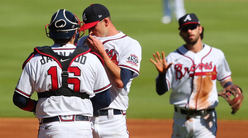 Braves catcher Travis d’Arnaud (16) confers with starting pitcher Drew Smyly as shortstop Dansby Swanson (background) approaches the mound after Smyly gave up a two-run homer to Arizona Diamondbacks David Peralta in the first inning of the second game of a doubleheader Sunday, April 25, 2021, at Truist PArk in Atlanta. Smyly relinquished five runs during the first inning. (Curtis Compton / Curtis.Compton@ajc.com)