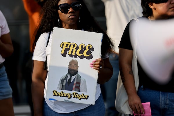Mildred Danis-Taylor, wife of Rodney Taylor, holds a sign at a protest against Immigration and Customs Enforcement at Hartsfield-Jackson airport in Atlanta on Monday, March 23, 2026. Taylor, a double amputee, has been in ICE custody for over a year. (Arvin Temkar/AJC)