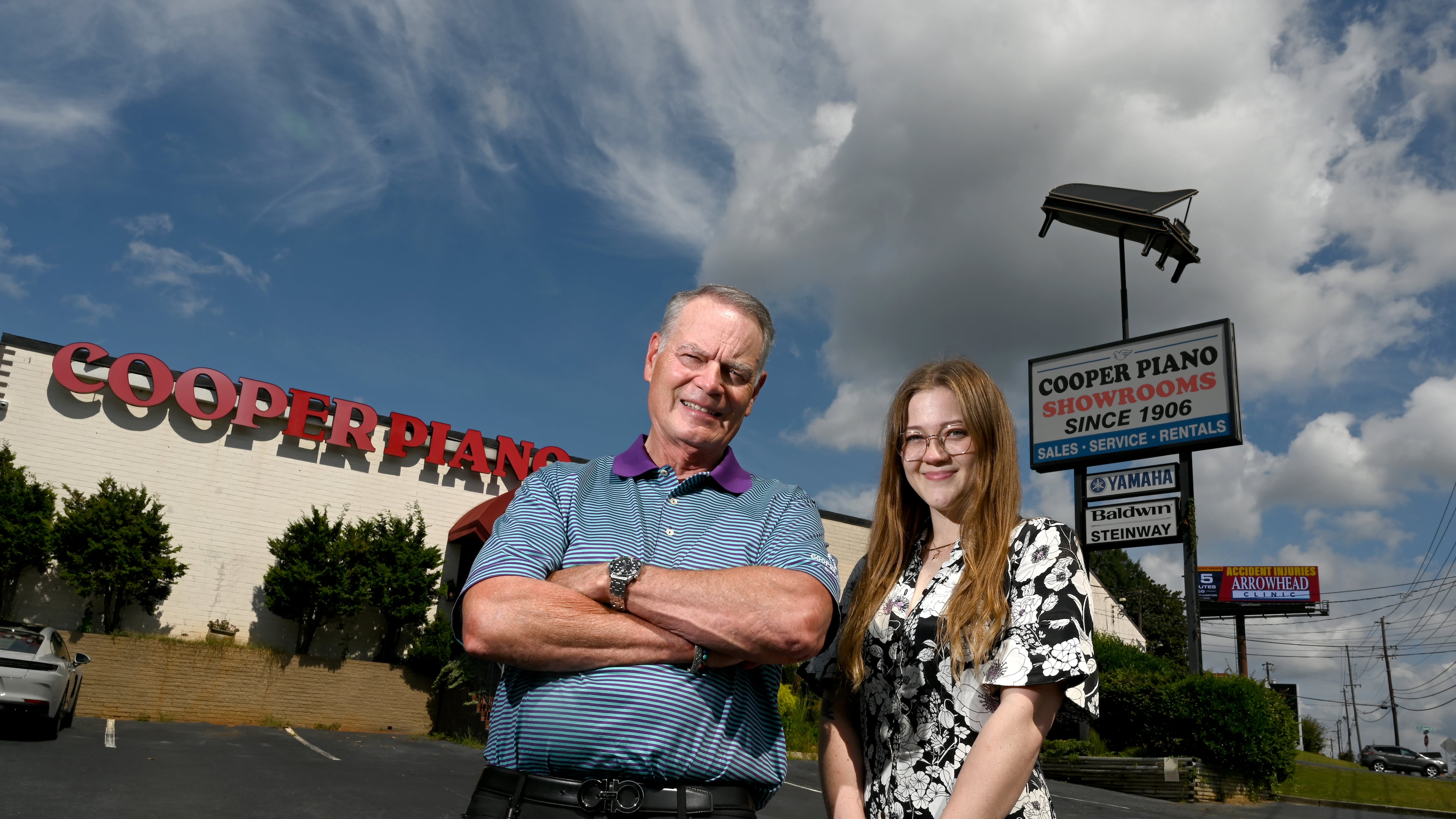 Blake Cooper, president of Cooper Piano, and his niece, Laura Cooper, outside the store in Brookhaven. After more than four decades on I-85, Cooper Piano is moving to a new store in Chamblee. That means the music shop is removing the landmark grand piano sign that towers above the nearby interstate. (Hyosub Shin/AJC)