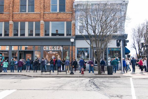 In this photo provided by Burrill Strong, supporters of Serendipity Books pass the store's books hand to hand, helping move the business to a new storefront about a block away from its current location, Sunday, April 13, 2025, in Chelsea, Mich. (Burrill Strong via AP)