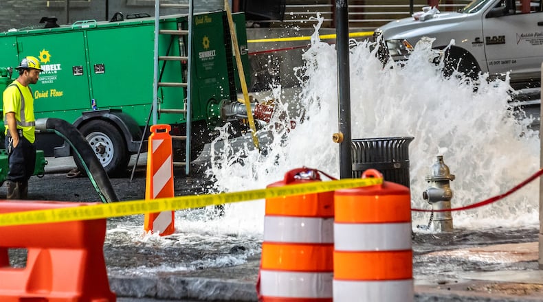 Crews are continuing to work on a broken main on West Peachtree Street at 11th Street in Midtown, with nearby residents warned of impacts to their water service as the crisis reached its fourth day Monday, June 3, 2024. Water had been gushing out of the broken main until Monday morning, when workers were seen pumping out water. (John Spink/AJC)