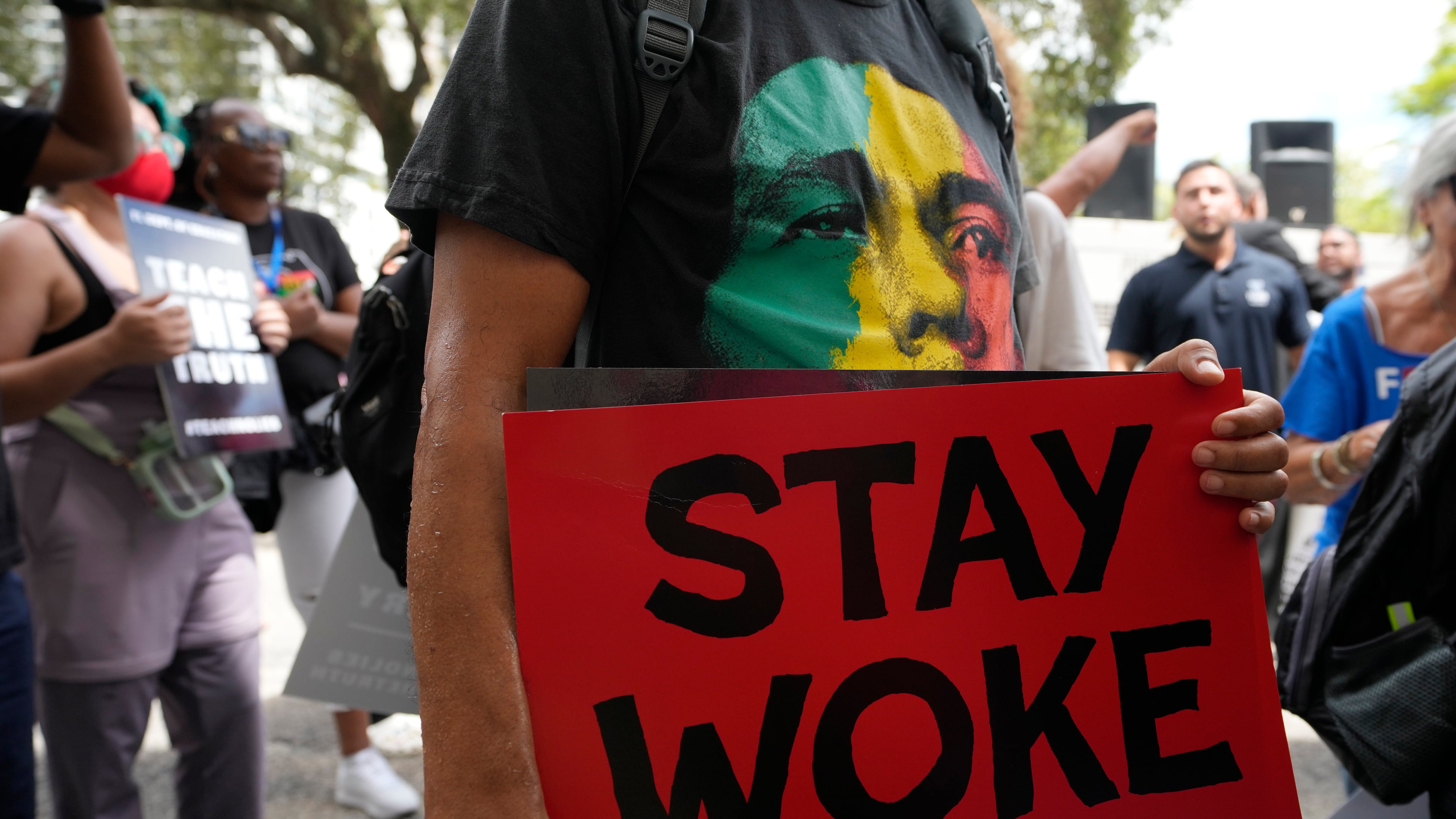 FILE - A person carries a sign during a march to protest Florida's new standards for teaching Black history, Aug. 16, 2023, in Miami. (AP Photo/Lynne Sladky, File)