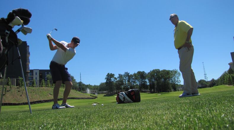 Vincent Whaley practices wedge shots while head coach Bruce Heppler looks on - Noonan Golf Facility, May 2, 2017