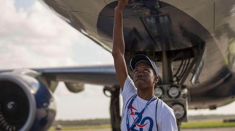 7/16/2019 -- Pensacola, Florida -- Camden Military Academy student and ACE camp participant Malik Williams strokes his hand under the belly of a Delta Air Lines plane after landing at Naval Air Station Pensacola during the 20th annual Delta Air Lines' "dream flight" aviation Summer camp, Tuesday, July 16, 2019. (Alyssa Pointer/alyssa.pointer@ajc.com)