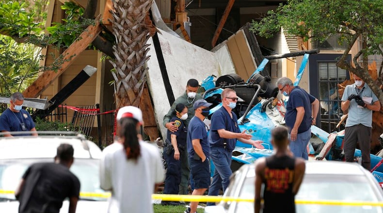 Authorities investigate the scene of a helicopter crash at an apartment complex in Houston, Saturday, May 2, 2020. Houston Police Chief Art Acevedo says the helicopter was carrying a pilot and a tactical flight officer when it went down at an apartment complex in north Houston around 2 a.m. Saturday. The cause of the crash wasn't immediately known. (Jon Shapley/Houston Chronicle via AP)/Houston Chronicle via AP)