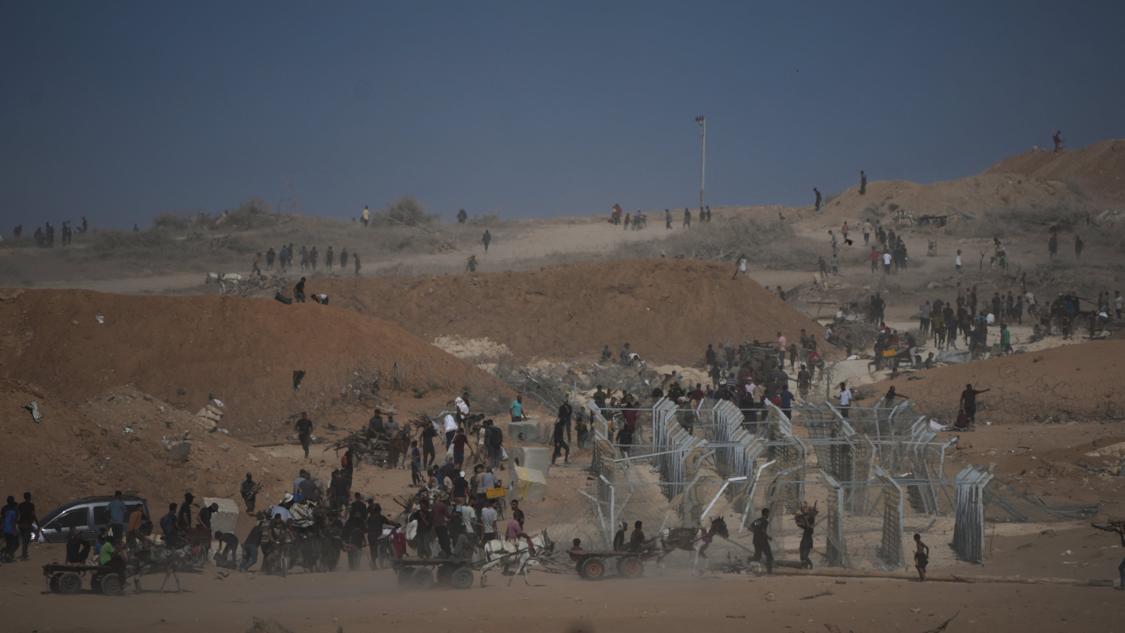 Palestinians inspect the remains of a site that housed a distribution center operated by the U.S.-backed Gaza Humanitarian Foundation (GHF) in Netzarim, central Gaza Strip, Friday, Oct. 10, 2025, after Israel and Hamas agreed to pause their war and release the remaining hostages. (AP Photo/Jehad Alshrafi)