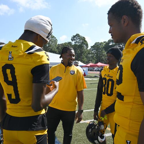Lithonia football head coach Kevin Barnes (center) speaks to his players during the DeKalb County School District Athletics Media Day at Napoleon B. Cobb Stadium on Thursday, July 16, 2026, in Decatur. (Hyosub Shin/AJC)