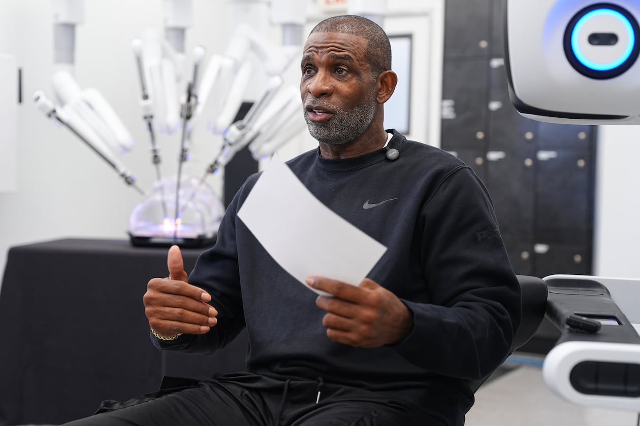 Colorado head football coach Deion Sanders talks after working the Da Vinci robotic surgical machine used to remove his cancerous bladder last year, during a demonstration of the device, Tuesday, June 23, 2026, in Boulder, Colo. (David Zalubowski/AP)