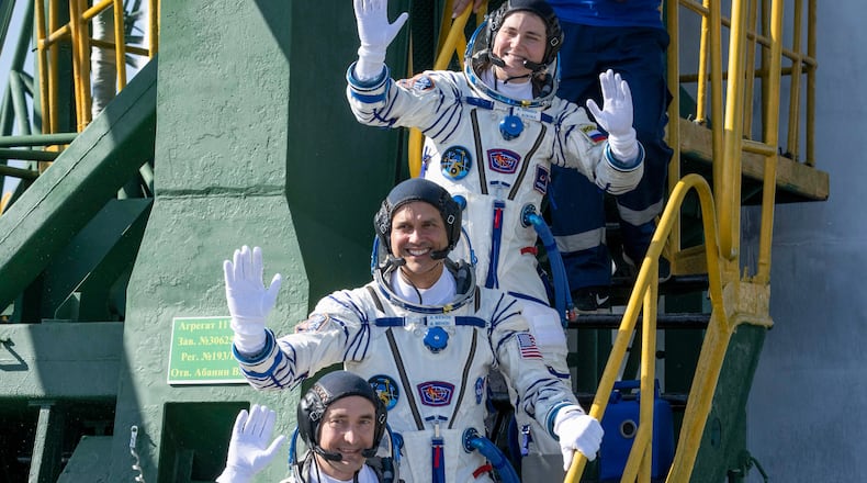 Expedition 75 Roscosmos cosmonaut Anna Kikina, top, NASA astronaut Anil Menon, middle, and Roscosmos cosmonaut Pyotr Dubrov, bottom, wave farewell prior to boarding the Soyuz MS-29 spacecraft for launch, Tuesday, July 14, 2026 at the Baikonur Cosmodrome in Kazakhstan. (Bill Ingalls/NASA via AP)