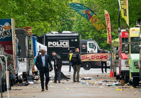 Vancouver Police detectives walk along where a car drove through a crowd killing multiple people on the weekend in Vancouver, British Columbia, Monday April 28, 2025. (Rich Lam/The Canadian Press via AP)