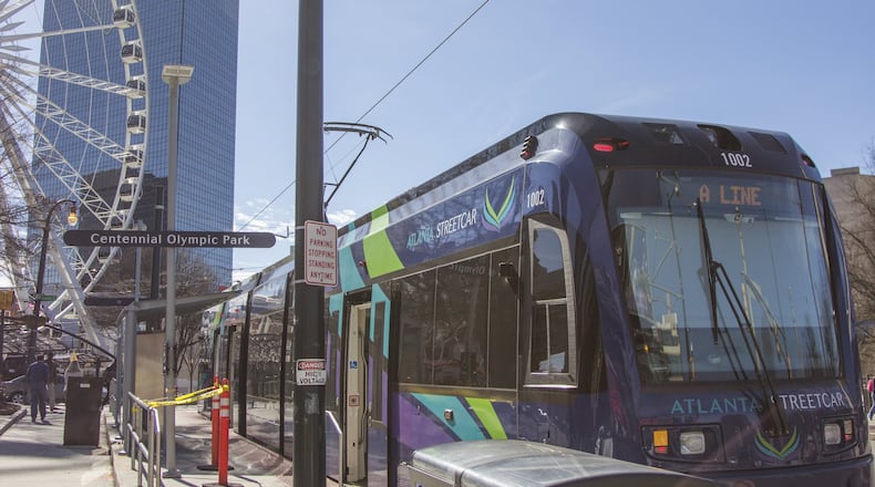 The Atlanta Streetcar makes its stop at Centennial Olympic Park with the SkyView looming at left. (AJC 2020)