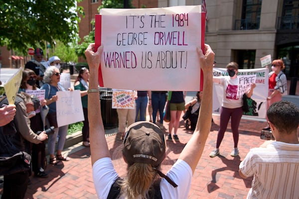 A supporter of Badar Khan Suri holds a sign saying "It's the 1984 George Orwell Warned Us About!," while attending a rally in opposition to the Georgetown University scholar's arrest and detention, outside of the courthouse, at the Federal District Court for the Eastern District of Virginia, in Alexandria, Va., Thursday, May 1, 2025. (AP Photo/Jacquelyn Martin)
