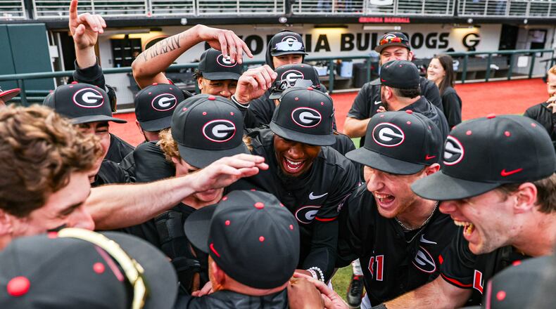 Georgia baseball players affectionately mob coach Wes Johnson during Georgia’s season-opening game against North Carolina-Asheville at Foley Field in Athens, Ga., on Friday, Feb. 16, 2024. Georgia won 11-2 in Johnson's debut as coach. (Kari Hodges/UGA Athletics)
