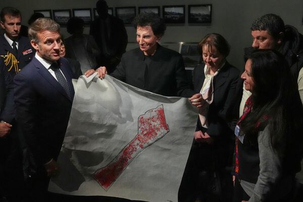French President Emmanuel Macron, left, and IMA director Jack Lang, center, hold a map of Palestine as they visit the exhibition "Treasures rescued from Gaza" Monday, April 14, 2025 at the Arab World Institute (IMA) in Paris. (AP Photo/Michel Euler, Pool)