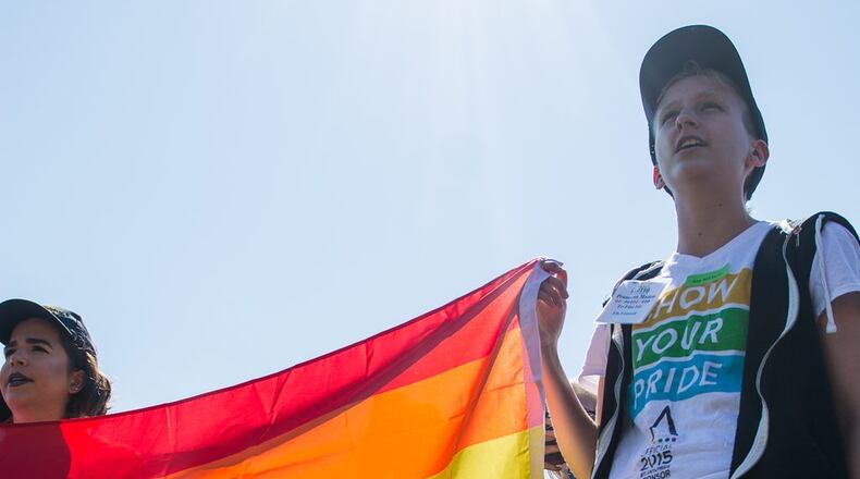A Kennesaw State student holds an LGBT flag during a protest at the school. (AJC/Cory Hancock)