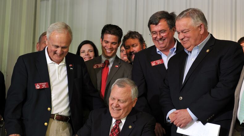 Surrounded by bill supporters, Governor Nathan Deal signs House Bill 60 into law during a signing event in Ellijay, GA. The gun law is a broad loosening of Georgia’s gun restrictions. BRANT SANDERLIN /BSANDERLIN@AJC.COM .