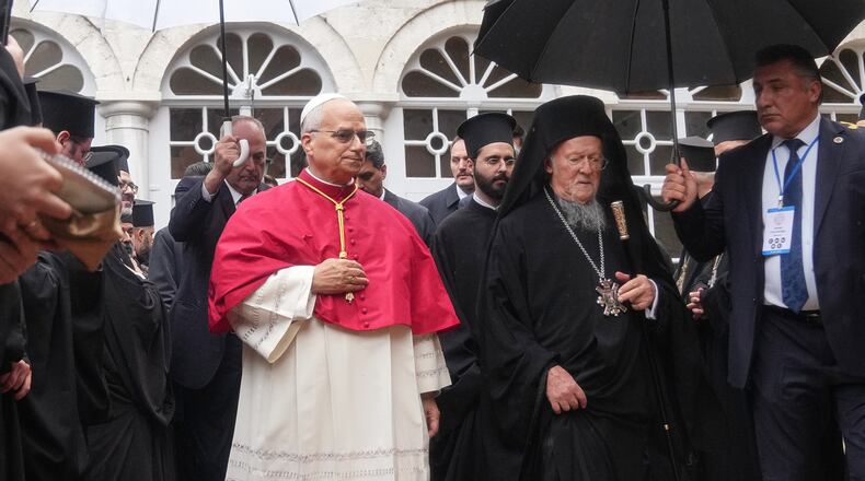 Pope Leo XIV and Ecumenical Patriarch Bartholomew I, the spiritual leader of the world's Eastern Orthodox Christians leave after a doxology service at the Patriarchal Church of Saint George, in Istanbul, Turkey, Saturday, Nov. 29, 2025. (AP Photo/Francisco Seco)
