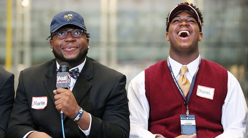 Grayson High School defensive tackle Chris Martin (left), wearing his Georgia Tech hat and bow tie, has teammate Bryce Morias (right), who is headed to Boston College, breaking out in laughter during national signing day ceremony at the College Football Hall of Fame Wednesday, Feb,. 3, 2016, in Atlanta. (Curtis Compton / AJC)