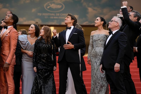 FILE - Tom Cruise, center, poses with the Greg Tarzan Davis, from left, Keleigh Sperry, Linda Bruckheimer, Jennifer Connelly, festival director Thierry Fremaux, and Jon Hamm after French Alpha Jets Patrouille de France fly over the red carpet at the premiere of the film 'Top Gun: Maverick' at the 75th international film festival, Cannes, southern France, Wednesday, May 18, 2022. (AP Photo/Petros Giannakouris, File)