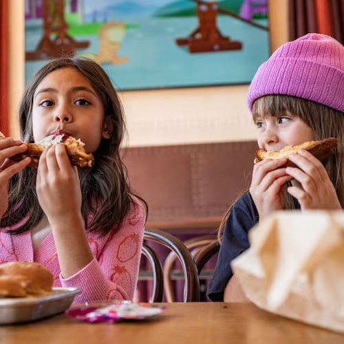 Two girls eat a grilled cheese sandwich from Bona Fide Deluxe's kids' menu.