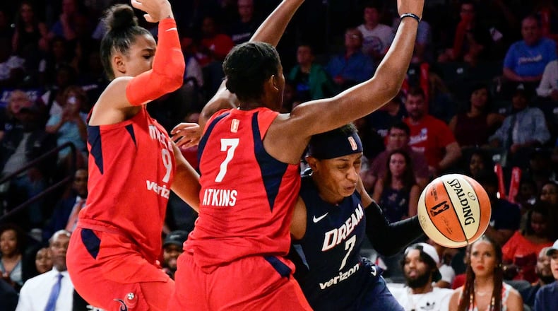 Dream guard Brittney Sykes (7) drives against Washington Mystics guard Ariel Atkins (7) and guard Natasha Cloud, left, during the first half of Game 5 of a WNBA basketball playoffs semifinal Tuesday, Sept. 4, 2018, in Atlanta. (AP Phot