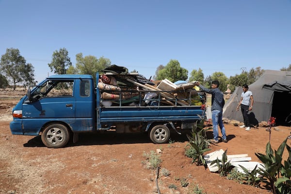 In this photo released by the Syrian official news agency SANA, Bedouin people pack their belongings onto a truck, as they flee their villages after Druze militias launched revenge attacks following days of clashes in Sweida city, southern Syria, Thursday, July 17, 2025. (SANA via AP)