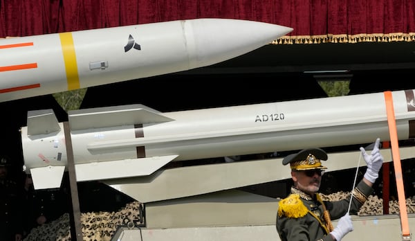 FILE - Missiles are carried on a truck as an Iranian army band leader conducts the music band during Army Day parade at a military base in northern Tehran, Iran, Wednesday, April 17, 2024. (AP Photo/Vahid Salemi, File)