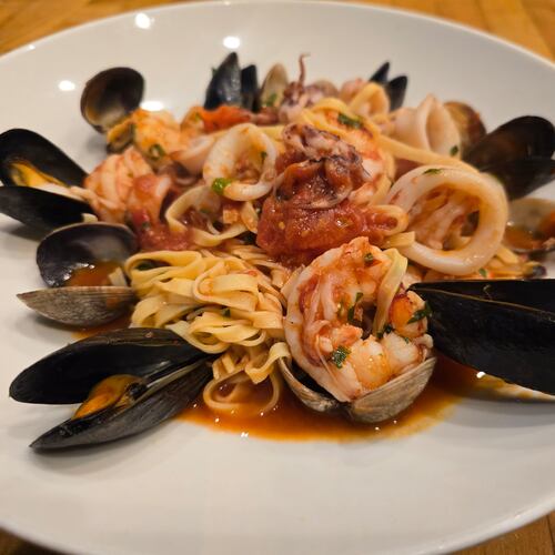 A plate of seafood linguine with mussels, clams, shrimp and a light tomato sauce