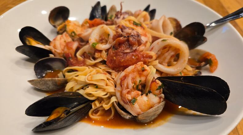 A plate of seafood linguine with mussels, clams, shrimp and a light tomato sauce