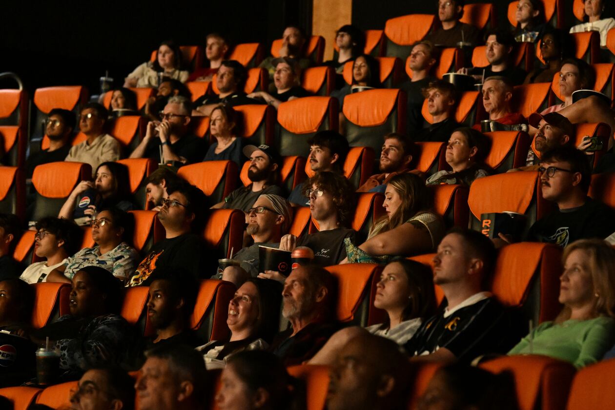 Moviegoers watch previews before a screening of “The Odyssey,” presented in IMAX 70mm film, at the Regal Mall of Georgia on Friday, Aug. 7, 2026, in Buford. The theater has been open for 24 hours Thursday through Monday since the film’s release. (Hyosub Shin/AJC)