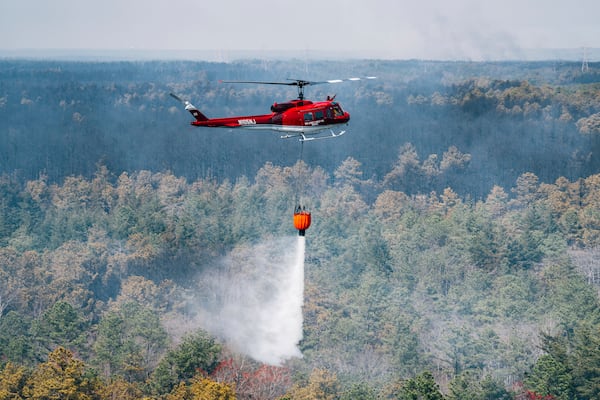 A helicopter drops water on a wildfire in Ocean County, N.J. on Thursday, April 24, 2025. (New Jersey Department of Environmental Protection via AP)