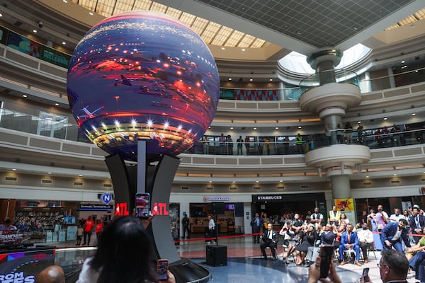 People record during the unveiling of Atlas, a new digital sphere, at the Hartsfield-Jackson Atlanta International Airport in Atlanta on Tuesday, June 2, 2026. (Abbey Cutrer/AJC)