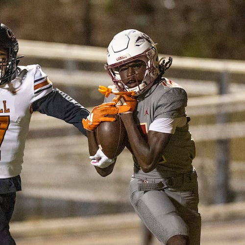 Creekside wide receiver Armani Hill (right) makes a catch while Kell defensive back Robert Tyson Jr. tries to intercept during the Class 4A semifinals last season. Both teams are playing in a higher class this season. (Oscar Guevara Saenz for the AJC)