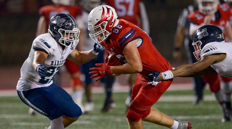 Marietta free safety Rashun Bass (11) and fullback James Knox (27) work together to tackle Milton tight end Jack Nickel during a Class 7A playoff game last season. (Daniel Varnado/Special)