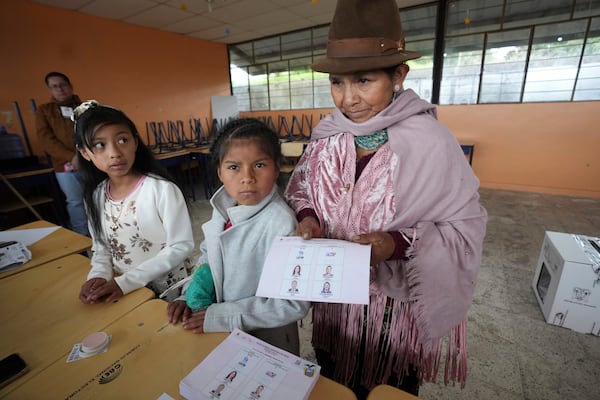 A voter holds her ballot during the presidential election runoff in Pujili, Ecuador, Sunday, April 13, 2025. (AP Photo/Dolores Ochoa)