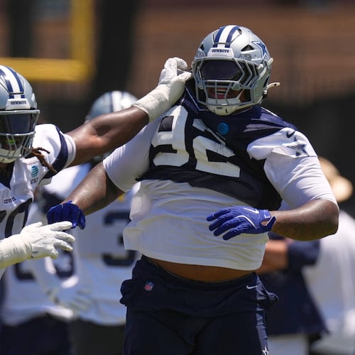 Dallas Cowboys offensive tackle Tyler Guyton, left, holds defensive tackle Quinnen Williams back during the NFL football team's training camp, Saturday, Aug. 1, 2026, in Oxnard, Calif. (AP Photo/Mark J. Terrill)