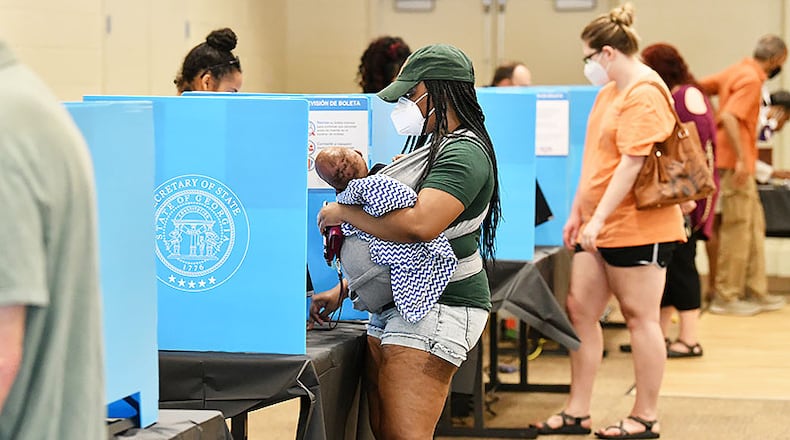 Caption: June 9, 2020 Norcross - Gwinnett County residents including Latanya Adams (center) with her 4-months old son Princeton cast their votes during the Georgia primary elections at Pinckneyville Community Center in Norcross on Tuesday, June 9, 2020. “I like new voting machine. It was easier to use.” Adams said.