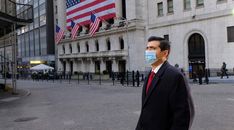 An unidentified man wears a facial mask near the New York Stock Exchange in March. Intercontinental Exchange, the Atlanta-based owner of the NYSE and other financial marketplaces, has seen a boom in revenue and profits as the coronavirus pandemic spread financial volatility around the world and boosted trading volume and demand for data that the company provies. (Luiz C. Ribeiro/New York Daily News/TNS)
