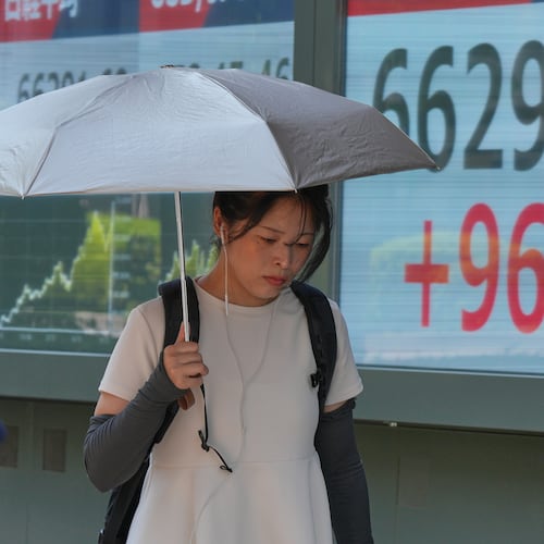 A person walks in front of an electronic stock board showing Japan's Nikkei index at a securities firm Thursday, Aug. 20, 2026, in Tokyo. (AP Photo/Eugene Hoshiko)